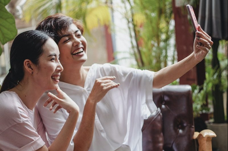 Cheerful Asian friends resting in cafe