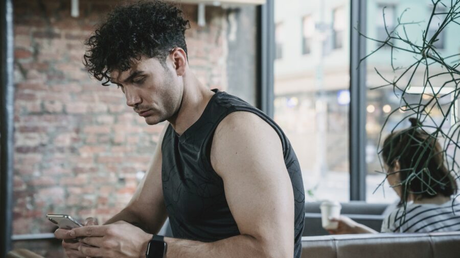 A Man Using a Cellphone Indoors